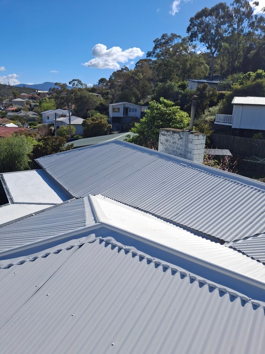 Corrugated iron roof after painting — freshly painted light grey finish